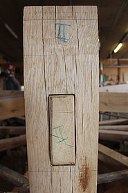 Ein Holzbalken mit eingezapftem Kopfholz  und Nummerierung