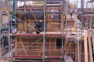 Baustelle mit Gerüst. Originales Teil wird eingesetzt
