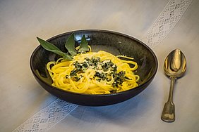 Salbeispaghetti in einer dunklen Keramikbowl, rechts liegt ein alter Silberlöffel