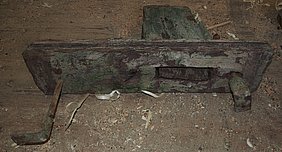 Das Foto zeigt ein Detail des alten Mühlrads: das Kopfholz sitzt quer auf der Speiche, verbunden mit einer Verzapfung.