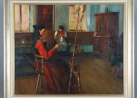 Das Bild zeigt eine Frau. Sie sitzt an einem Spinnrad. Im Hintergrund sitzt noch eine Person auf einer Bank. Es sind ein Schrank und ein Tisch zu sehen. Der Raum hat zwei Fnester. Die Wände sind bläulich. Der Boden ist aus Holz.
