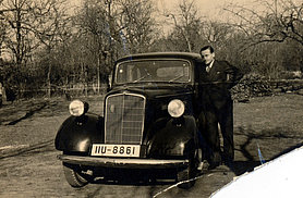Schwarz-Weiß Foto von Ignace Rhodes vor einem Automobil