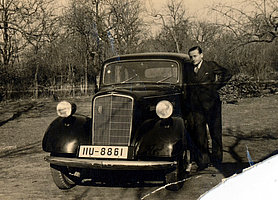 Schwarz-Weiß Foto von Ignace Rhodes vor einem Automobil