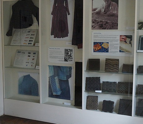 Ausstellungsvitrine mit Model für Stoffdruck und Fotos von bedruckten Textilien