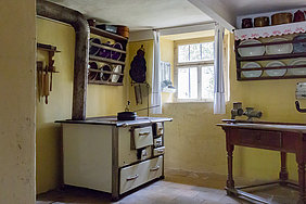 In der Küche im Bauernhaus aus Herrnberchtheim stehen zwei irdene Napfkuchenformen im Schüsselrahmen über dem Herd, Foto Margarete Meggle-Freund