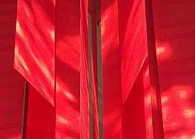 Rote Tücher, die von der Decke hängen.