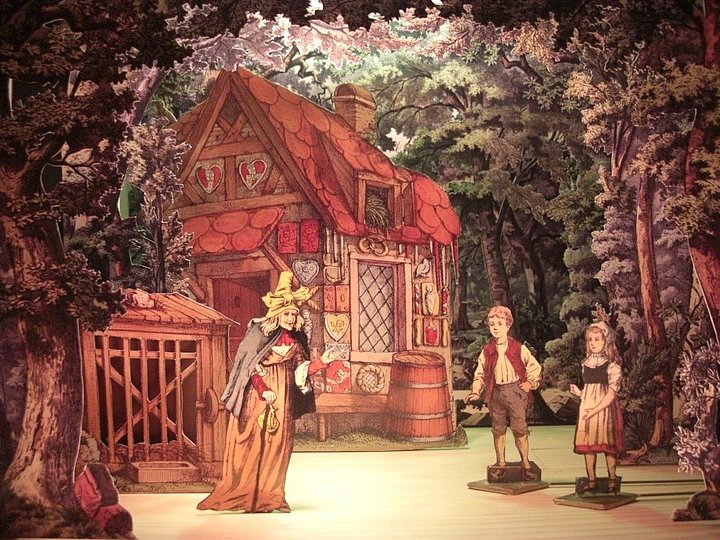 Hänsel und Gretel mit Hexe vor einem Haus