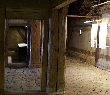 Texttaflen und mächtige Holzsäule im Inneren des Bauernhauses