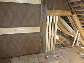 Innenansicht des Dachgeschosses mit Fachwerk und frischem Lehmputz