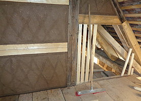Innenansicht des Dachgeschosses mit Fachwerk und frischem Lehmputz