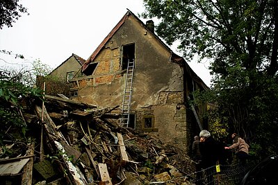 Das alte Haus ist kaputt. Es muss gemessen und repariert werden.