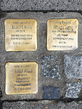 Drei goldene Stolpersteine in Bamberg mit den Namen der Familie Aron.