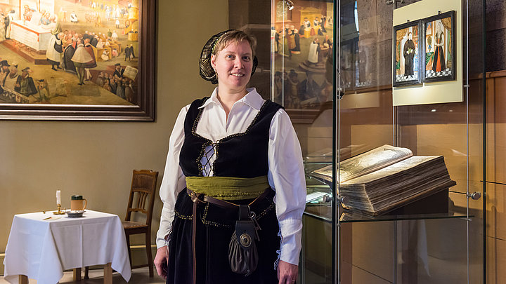 eine Museumsführerin als Katharina von Bora verkleidet vor Ausstellungsobjekten in der Spitalkirche Bad Windsheim