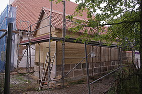 Blockbaukonstruktion mit Steinsockel und Satteldach