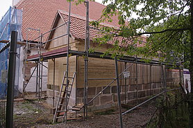 Blockbaukonstruktion mit Steinsockel und Satteldach