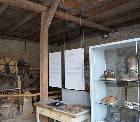 Historische Bandsäge und Ausstellungsvitrine mit verschiedenen Holzschuhtypen
