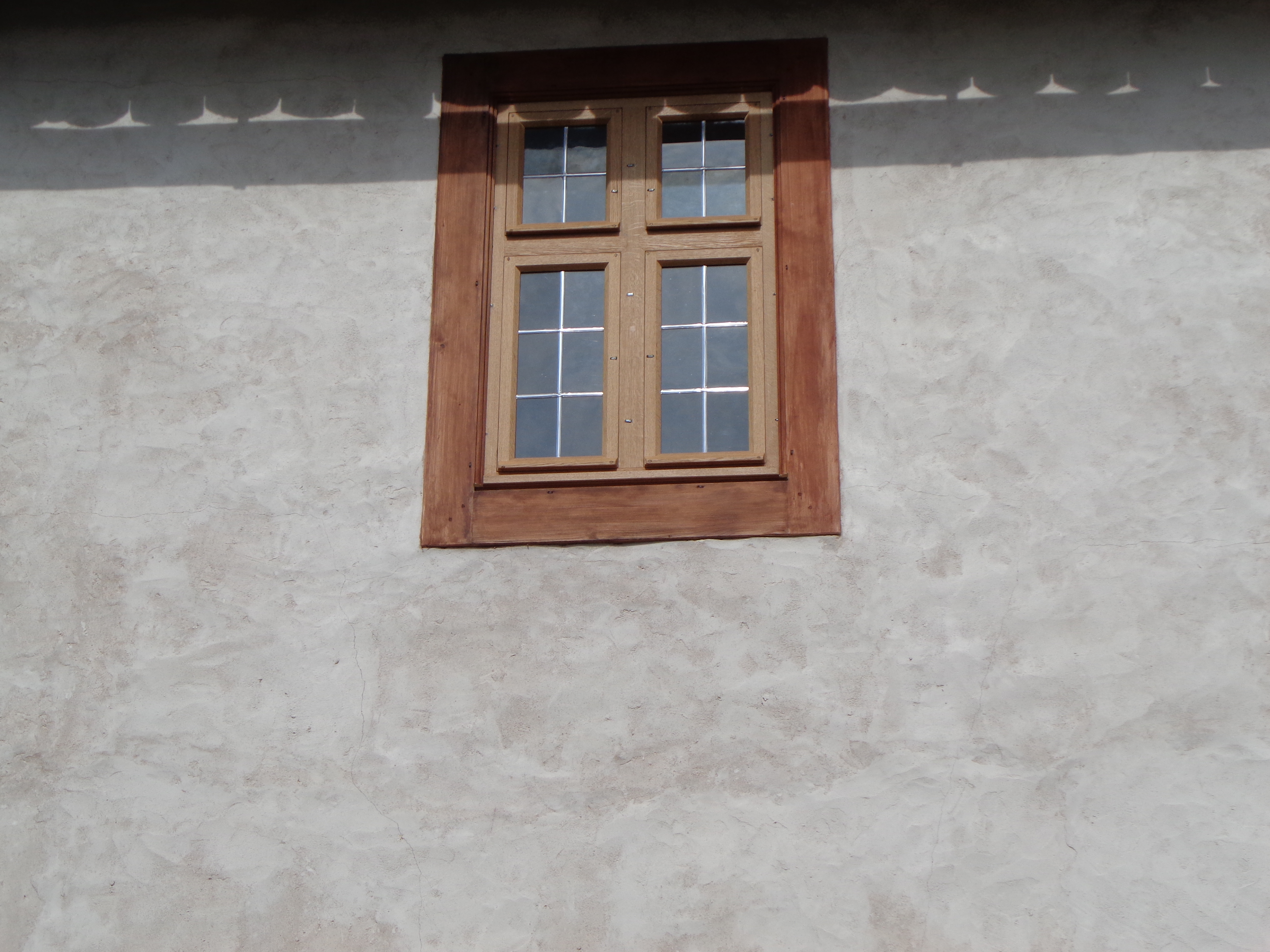 Fenster mit rötlichem Rahmen und Kreuzstock