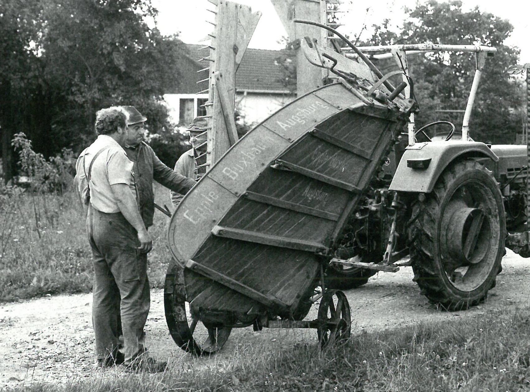 Schwarz-weiß Foto der Abholung eines landwirtschaftlichen Geräts mit zwei Peronen