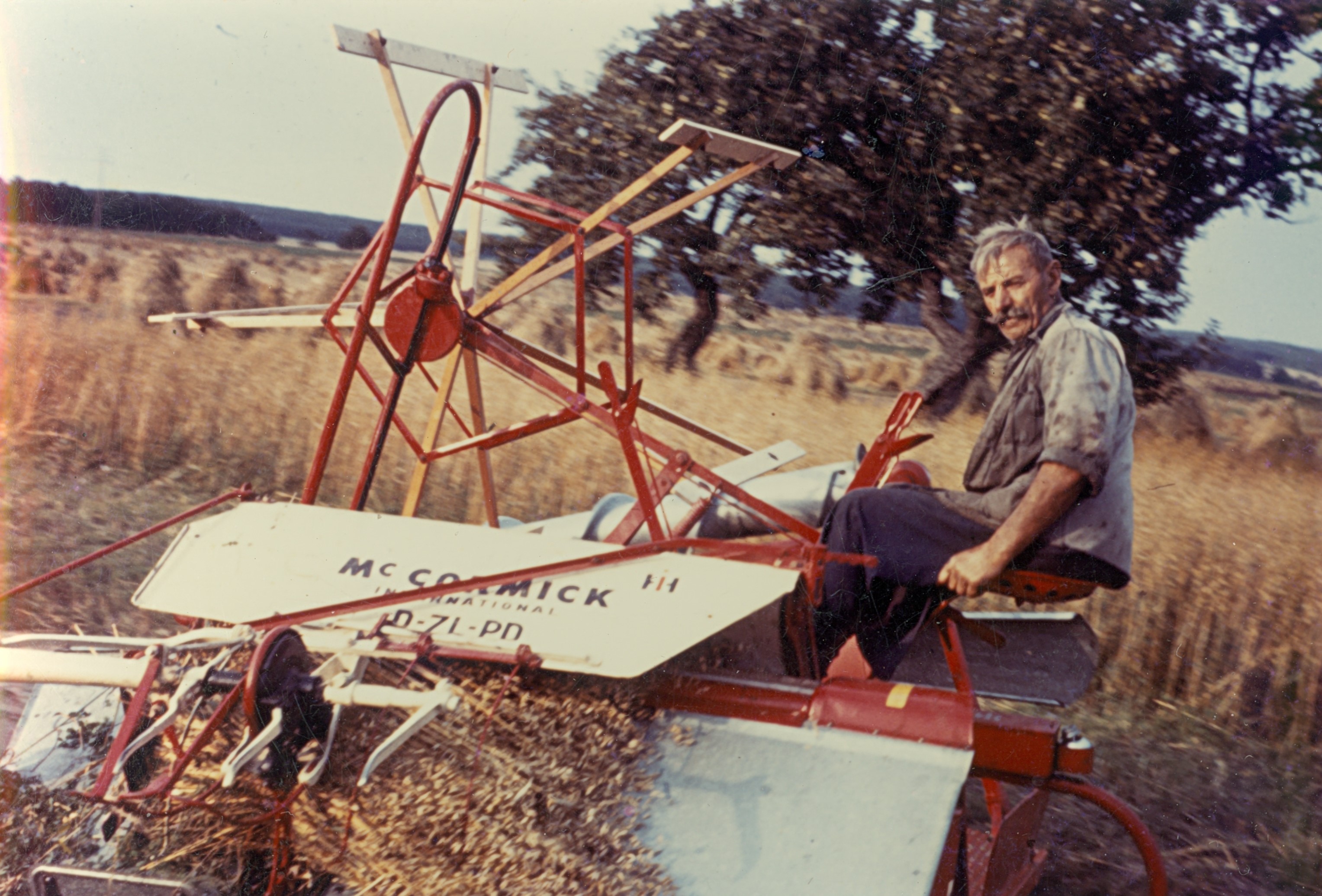historisches Foto mit Menschen auf einem landwirtschaftlichen Gerät