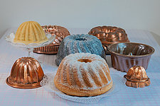 Gugelhupf und Gugelhupfbackformen aus Kupfer, grau gewölktem Emaile und glasierter Keramik, Kuchenplatte mit Stiel aus Pressglas, Foto Margarete Meggle-Freund